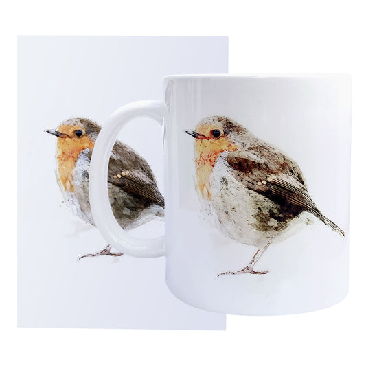 A glossy ceramic white coffee mug with a watercolour robin bird print, shown on top of a matching A6 greeting card against a white background